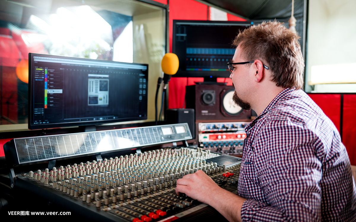 聲音制作人在錄音棚使用音板和監視器工作